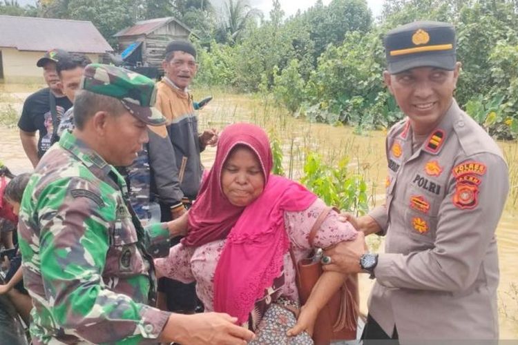 Personel Polres Aceh Barat membantu mengevakuasi masyarakat yang terjebak banjir di Desa Leuhan, Kecamatan Johan Pahlawan, Kabupaten Aceh Barat, Kamis (23/11/2023). 