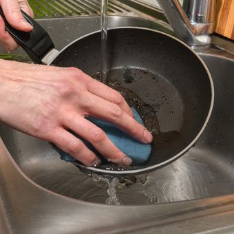 Ilustrasi mencuci peralatan dapur berwarna hitam