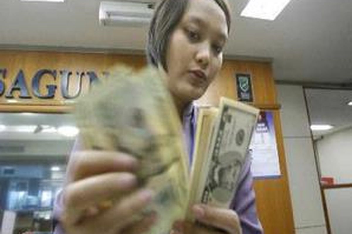 Karyawan penjualan valuta asing (valas) di kawasan Kwitang, Jakarta Pusat, menghitung lembaran uang dollar AS.