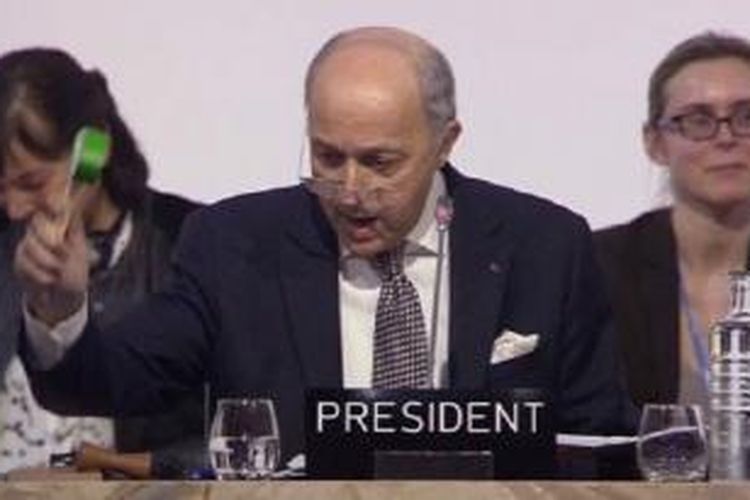 Laurent Fabius mengetuk palu yang kemudian disambut tepuk tangan meriah oleh peserta konferensi. 