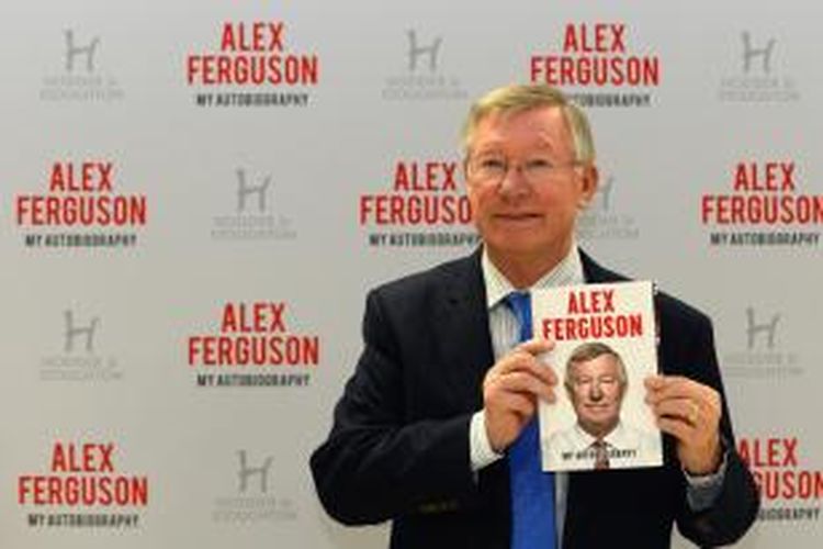 Alex Ferguson menunjukkan buku otobiografinya sebelum acara penandatanganan, di sebuah supermarket, di Manchester, 24 Oktober 2013. 