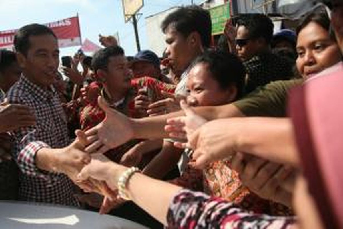 Warga berebut jabat tangan capres, Joko Widodo (Jokowi) yang tiba di Pasar Sokaraja, Banyumas, Jawa Tengah, Jumat (13/6/2014). Ribuan warga memenuhi halaman pasar untuk mendengarkan orasinya. Dalam kesempatan itu, ia menegaskan ingin menasionalkan program Kartu Indonesia Sehat dan Kartu Indonesia Pintar jika ia terpilih sebagai presiden.