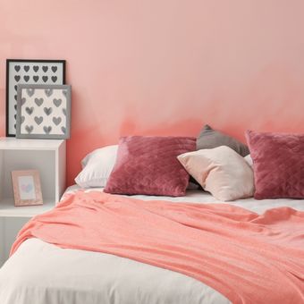 Ilustrasi kamar tidur dengan warna cat dinding merah muda atau pink. 