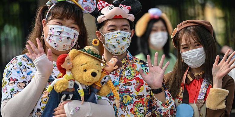 Pengunjung mengenakan masker saat mendatangi taman hiburan Disneyland, Shanghai, China, yang baru dibuka kembali, Senin (11/5/2020). Shanghai Disneyland resmi kembali dibuka setelah ditutup selama 4 bulan akibat pandemi virus corona.