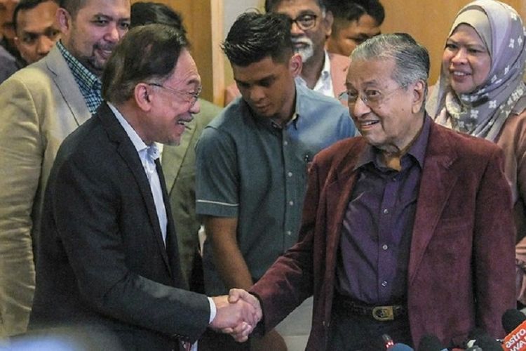 Presiden Partai Keadilan Rakyat (PKR) Anwar Ibrahim bersalaman dengan Perdana Menteri Malaysia Mahathir Mohamad setelah pertemuan Dewan Presidensial Pakatan Harapan, Jumat malam (21/02/2020)