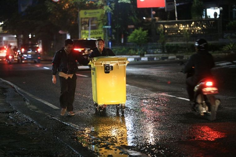 Petugas kebersihan Kota Bandung saat mendorong tempat sampah sementara dalam kegiatan operasi tangkap tangan pelaku pembuang sampah sembarangan di kawasan Jalan Cihampelas, Selasa (20/2/2018) malam. Selain menangkap pelaku, petugas juga turut memberi solusi dengan menyediakan bak sampah bagi warga yang kesulitan membuang sampah.