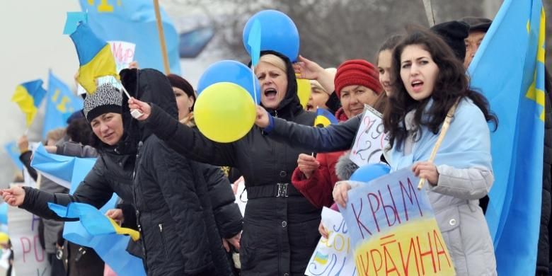 Para perempuan Tatar Crimea mengibarkan bendera Tatar dan Ukraina dalam sebuah unjuk rasa di kota Simferopol, Crimea, Sabtu (8/3/2014). Beberapa perempuan itu bahkan membawa spanduk dengan tulisan Crima = Tatar.