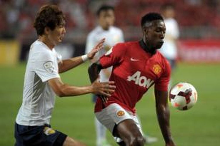 Striker Manchester United, Danny Welbeck (kanan), mendapat pengawalan ketat dari pemain Singha All Star XI, Kim Yoo-jin (kiri), pada laga persahabatan di Stadion Rajamangala, Bangkok, Sabtu (13/7/2013). Pada laga itu, MU secara mengejutkan takluk 0-1 dari Singha All Star XI.