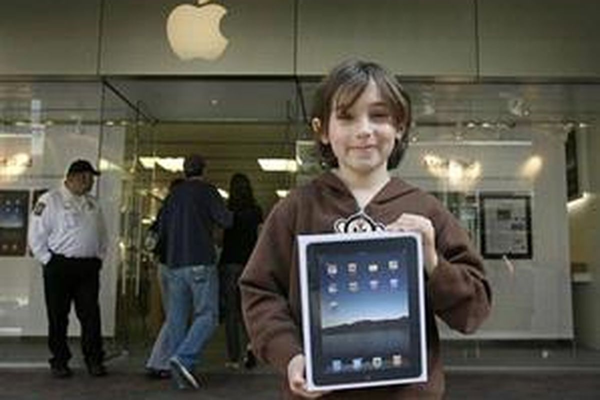 Henry Lear (8) dari Richmond, Virginia, membawa paket iPad yang baru dibelinya di Short Pump Town Center, Sabtu (3/4/2010).