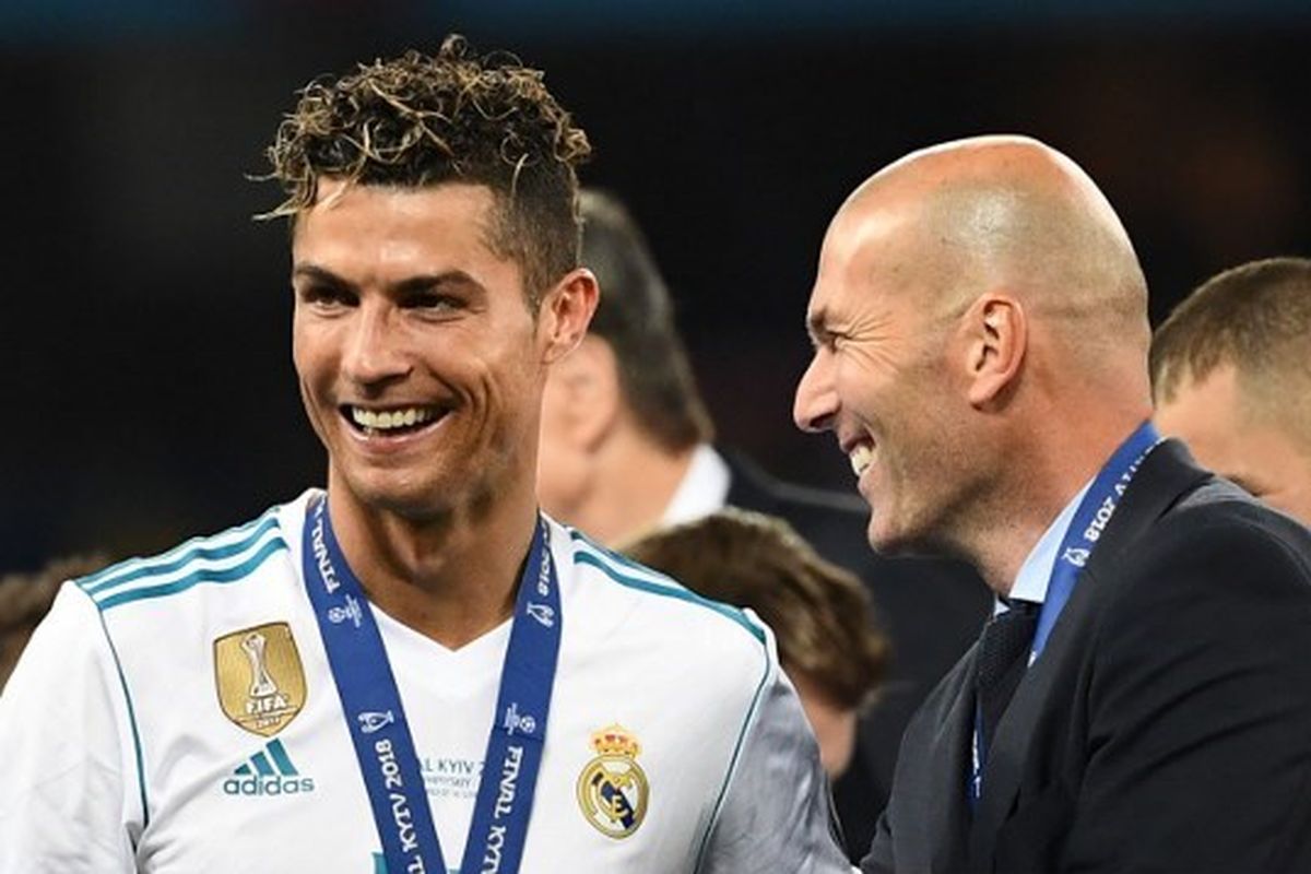 Pelatih Real Madrid, Zinedine Zidane, berselebrasi bersama Cristiano Ronaldo seusai juara Liga Champions 2018. Real Madrid juara setelah mengalahkan Liverpool di Stadion Olimpiyskiy, Ukraina, Sabtu (26/5/2018). Terkini, Ronaldo dikabarkan terlibat dalam proses penawaran agar Zidane bisa melatih Al Nassr. (Foto oleh FRANCK FIFE / AFP)