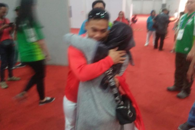 Lifter Indonesia, Eko Yuli Irawan, memeluk istrinya usai meraih medali emas Asian Games 2018.