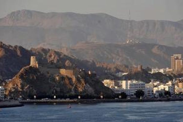 Lanskap kota Muskat, ibu kota Oman, dilihat dari laut lepas menunjukkan gugusan pegunungan tandus yang diubah menjadi kota memesona.