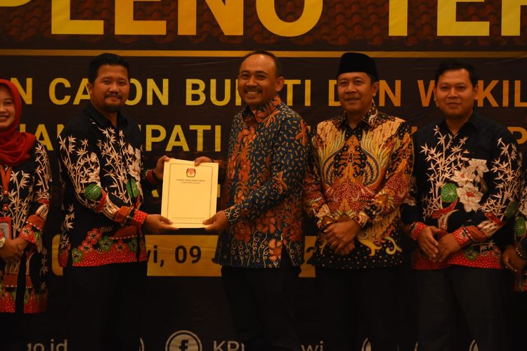 SERAHKAN--Ketua KPU Ngawi, Samsu Mustakim menyerahkan surat keputusan penetapan paslon nomor urut satu, Ony Anwar Harsono dan Dwi Rianto Jatmiko (Ony-Antok), sebagai bupati dan wakil bupati Ngawi pada Pilkada 2024, Kamis (9/1/2025).