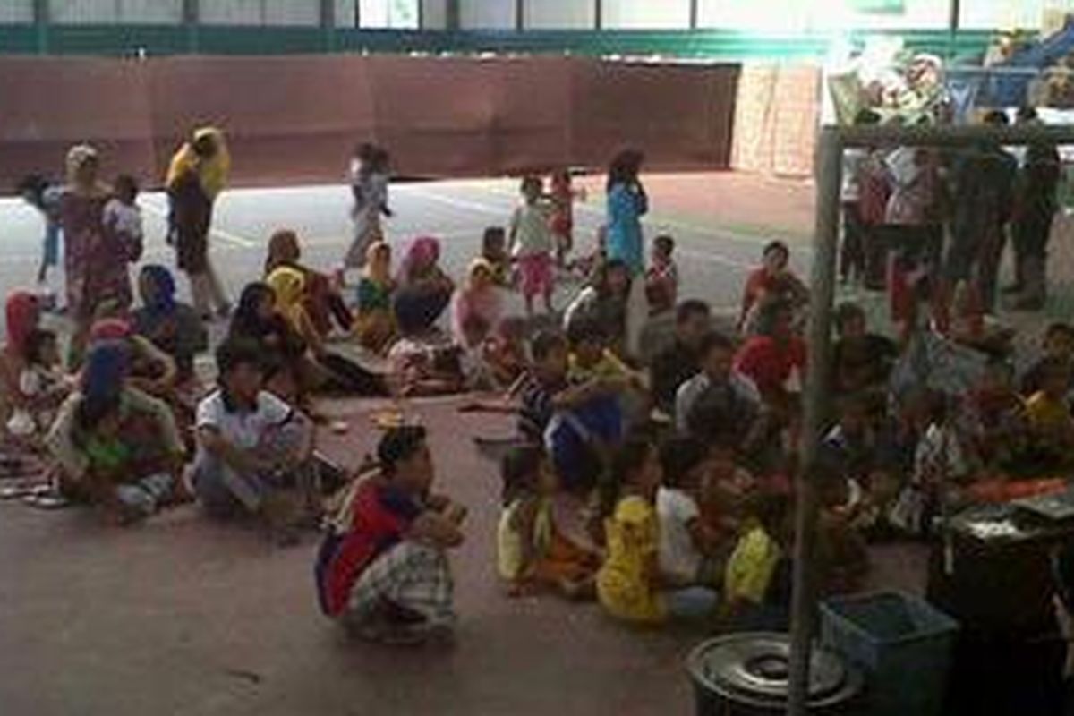 Anak-anak pengungsi Syiah menikmati tontonan gratis di dalam gedung pengungsian.