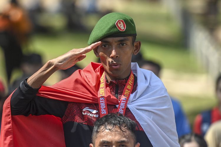 Pelari putra Indonesia Agus Prayogo memberi hormat saat upacara penyerahan medali marathon SEA Games 2023 di kawasan situs warisan budaya dunia UNESCO Angkor Wat, Siem Reap, Kamboja, Sabtu (6/5/2023). Pelari asal Jawa Barat tersebut berhasil meraih medali emas pertama untuk cabang atletik. ANTARA FOTO/Muhammad Adimaja/tom.