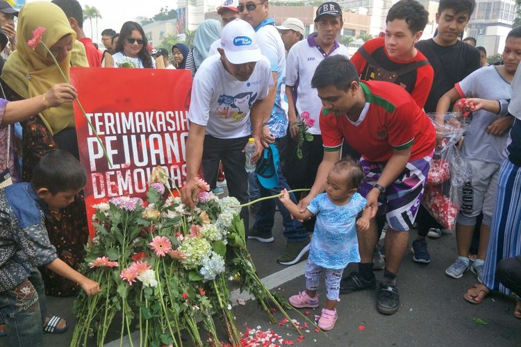 TKN Milenial Jokowi-Maruf mengajak masyarakat untuk tabur bunga sebagai bentuk belasungkawa atas meninggalnya petugas KPPS dalam Pemilu 2019, di area car free day, Bundaran HI, Sabtu (28/4/2019). 