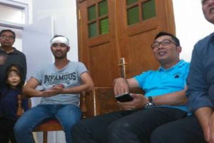 Vokalis band Pure Saturday, Satria Nur Bambang atau Iyo (dengan kening diperban), dijenguk oleh Wali Kota Bandung, Ridwan Kamil, di kediamannya di Bandung, Jawa Barat, Minggu (23/2/2014) sore.
