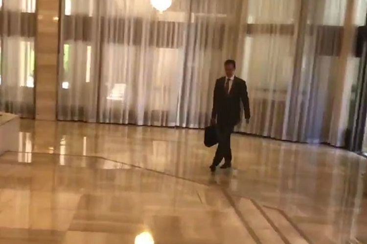 Dalam foto yang diambil dari video yang dirilis lewat Twitter ini terlihat Presiden Suriah Bashar al-Assad berjalan sambil menjinjing kopernya melintasi sebuah ruangan berlantai marmer.