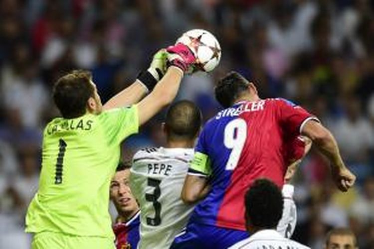 Kiper Real Madrid Iker Casillas (kiri) melakukan penyelamatan pada pertandingan fase grup Liga Champions, melawan FC Basel, di Santiago Bernabeu, 16 September 2014.