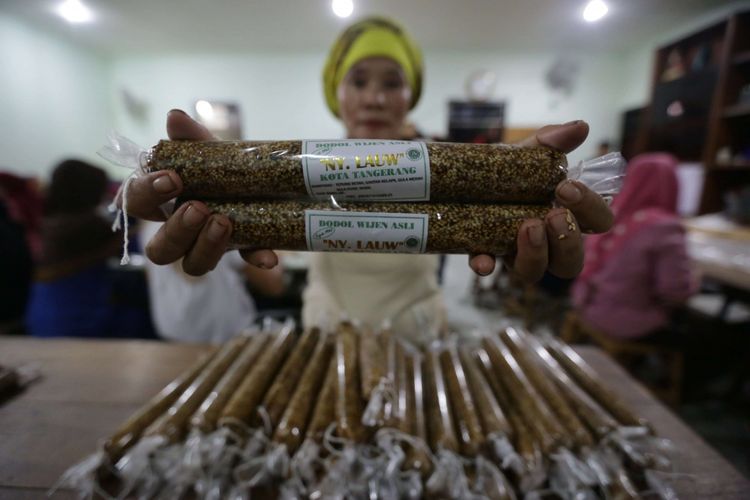 Pekerja membungkus dodol untuk dipasarkan di rumah produksi dodol nyonya Lauw di kawasan Tangerang, Banten, Senin (28/1/2019). Menjelang Imlek permintaan dodol betawi mengalami peningkatan tiga kali lipat dengan harga jual Rp53.000 per kilogramnya.