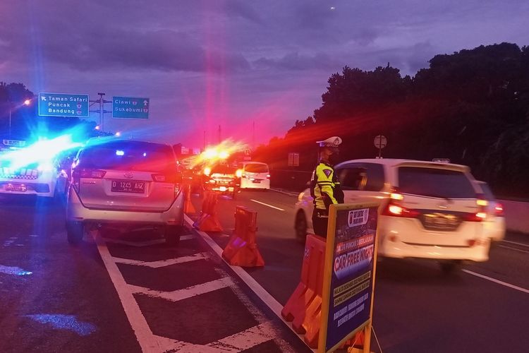 Petugas kepolisian sedang melakukan pengalihan arus kendaraan di Simpang Polingga KM 46 Tol Jagorawi, pintu GT Ciawi, Kabupaten Bogor, Jawa Barat, Sabtu (31/12/2022).