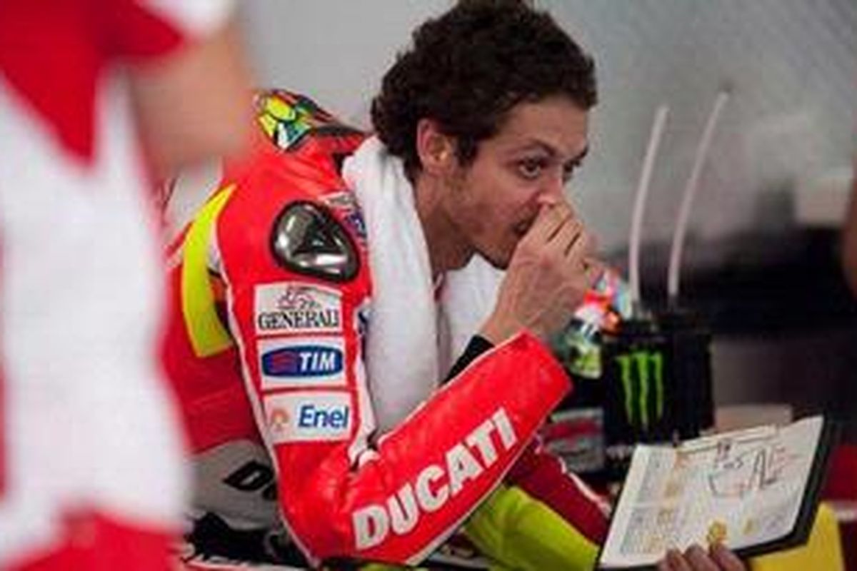 Pebalap Ducati, Valentino Rossi, duduk di garasi pada hari kedua uji coba resmi kedua di Sepang, Rabu (29/2/12).