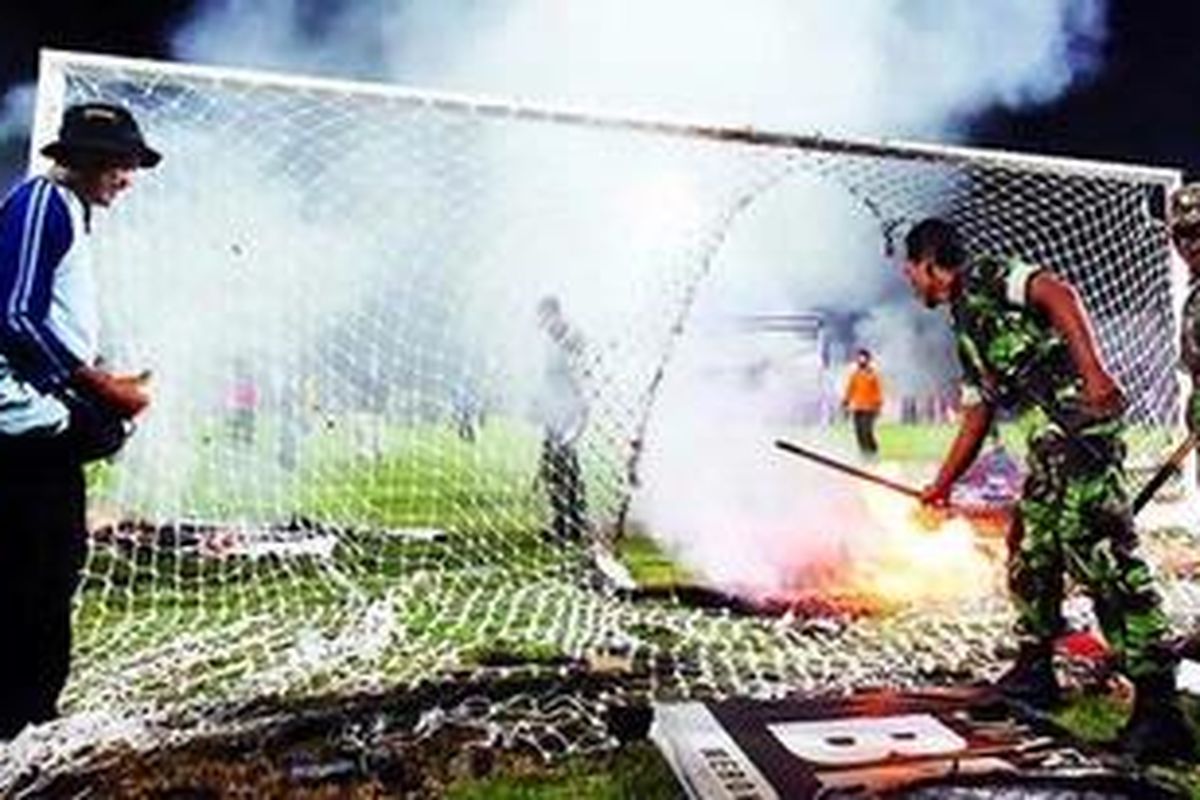 Petugas keamanan memadamkan api yang membakar papan sponsor dan jala gawang pada pertandingan Liga Djarum Super 2007 antara Persiwa Wamena dan Arema Malang di Kediri. Ini salah satu kerusuhan terburuk akibat pengelolaan kompetisi yang amburadul, yang jelas merugikan sponsor.