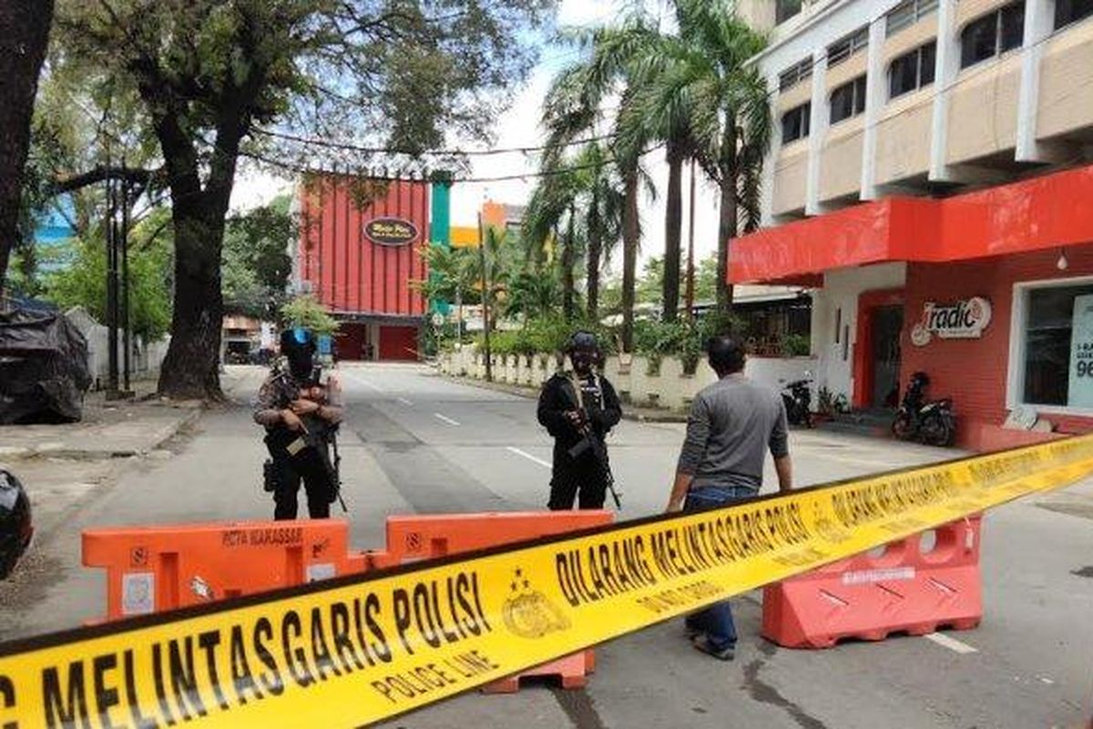 Police stand guard near the scene after an explosion in front of a cathedral in the Indonesian city of Makassar in South Sulawesi on Sunday, March 28, 2021. 