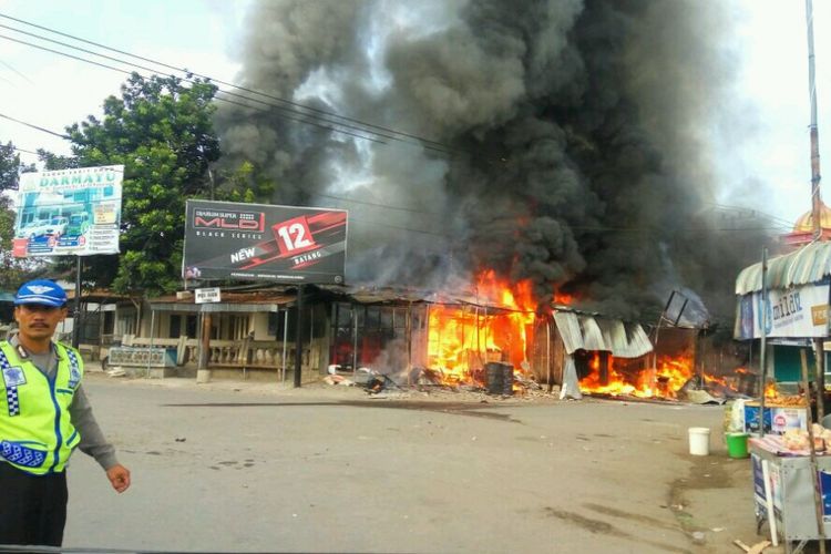 Api sementara membakar ruko di Pasar Sugihan, Kecamatan Pulung, Kabupaten Ponorogo, Jawa Timur, Minggu (2/7/2017).