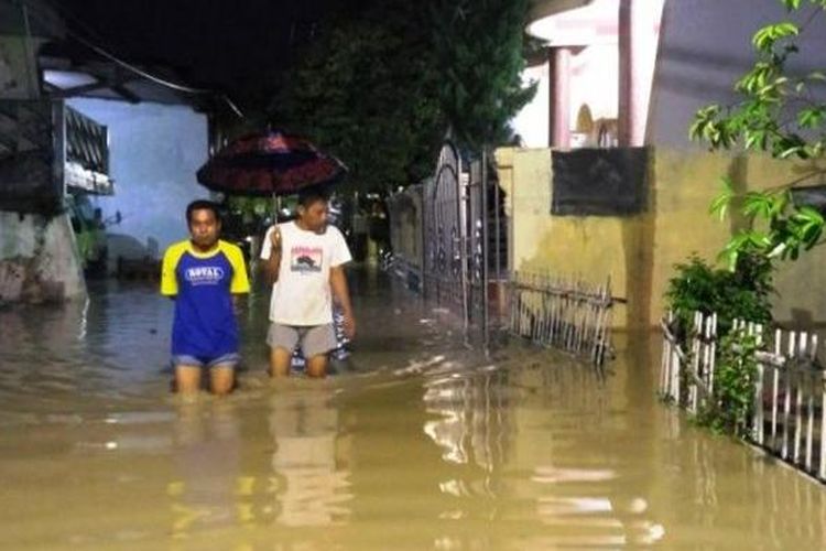 Warga berjalan menerobos banjir di Sawah Besar Gang XII, Kelurahan Kaligawe, Gayamsari, Kota Semarang, Senin (13/2/2017) malam. 