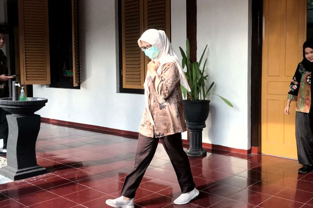 Mantan Bupati Blitar Rini Syarifah meninggalkan ruang aula Kejaksaan Negeri Kabupaten Blitar, Rabu (16/4/2025) sore.