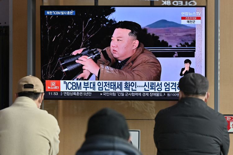 Orang-orang menonton layar berita televisi yang memperlihatkan gambar pemimpin Korea Utara Kim Jong Un menyaksikan uji coba penembakan rudal balistik antarbenua (ICBM) Hwasong-17 baru-baru ini, di sebuah stasiun kereta api di Seoul pada 17 Maret 2023. Korea Utara berkata proyektil yang ditembakkan pada 16 Maret adalah rudal balistik antarbenua yang dikenal sebagai Hwasong-17, lapor kantor berita negara KCNA. 