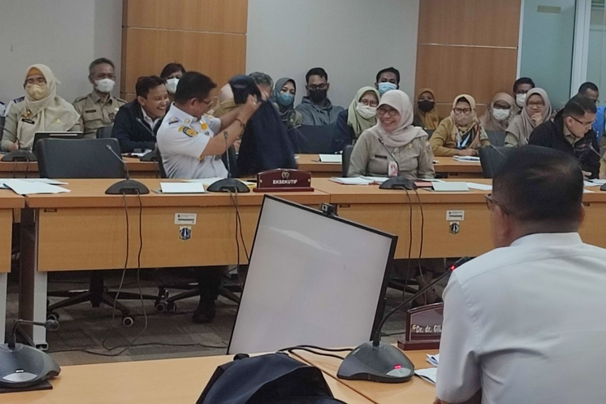 Kadishub DKI Jakarta, Syafrin Liputo saat melepas jaket berwarna biru dongker yang dikenakan dalam rapat rapat kerja Komisi B DPRD DKI Jakarta yang digelar pada Senin (3/4/2023). 