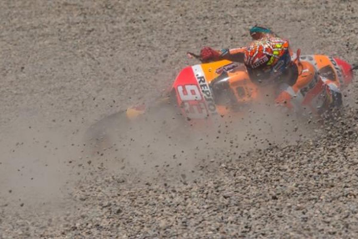 Pebalap Repsol Honda asal Spanyol, Marc Marquez, terjatuh di gravel saat menjalani balapan GP Catalunya di Sirkuit de Barcelona, Minggu (14/6/2015).