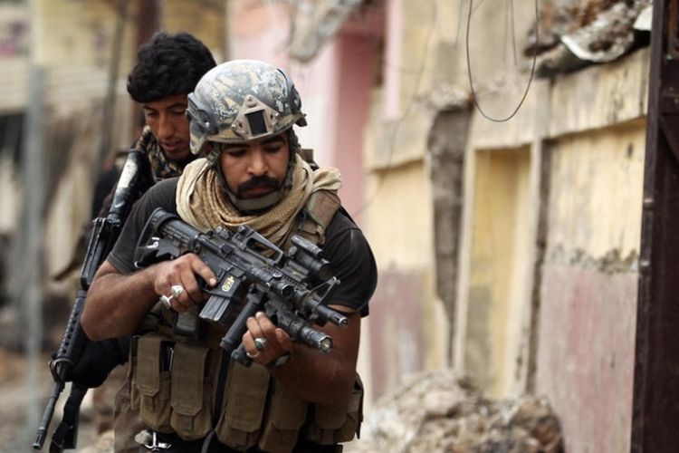 Personel pasukan anti-teror Irak bergerak maju di sebuah kawasan permukiman di sisi barat kota Mosul.