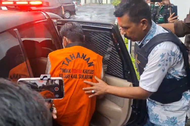 Kepala Dinas Lingkungan Hidup Kabupaten Sukabumi, saat mengenakan pakaian tahanan dan lengan diborgol saat tengah akan dibawa ke Rutan Warungkia.