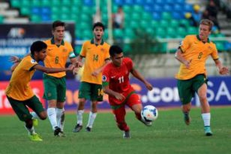 Pemain Indonesia, Hendra Sandi Gunawan dikepung pemain Australia saat kedua tim bertanding dalam turnamen Piala AFC U-19 di Stadion Thuwunna, Yangon, Minggu (12/10/2014). Indonesia menyerah 0-1.