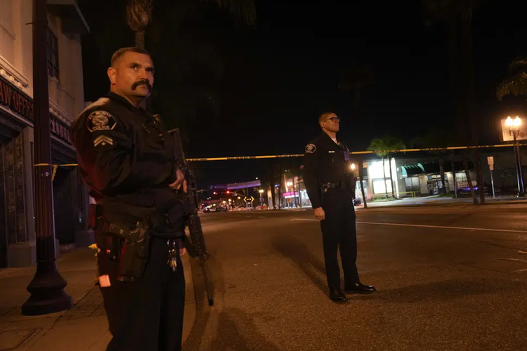 Dua polisi berjaga di dekat lokasi terjadinya penembakan di Monterey Park, California, Minggu, 22 Januari 2023. Puluhan polisi menanggapi laporan adanya penembakan yang terjadi setelah perayaan besar Tahun Baru Imlek berakhir pada sebuah komunitas di timur Los Angeles Sabtu malam. 