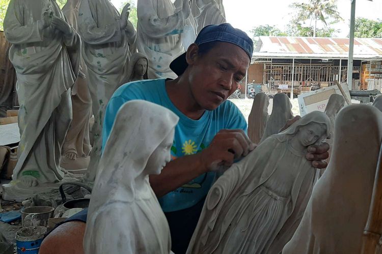 Pekerja menyelesaikan pembuatan patung rohani di industri pembuatan patung fiber milik Fransiskus Asisi Tri Atmojo, Desa Sumbermulyo, Kecamatan Bambanglipuro, Kabupaten Bantul, Yogyakarta Jumat (20/12/2019) siang.
