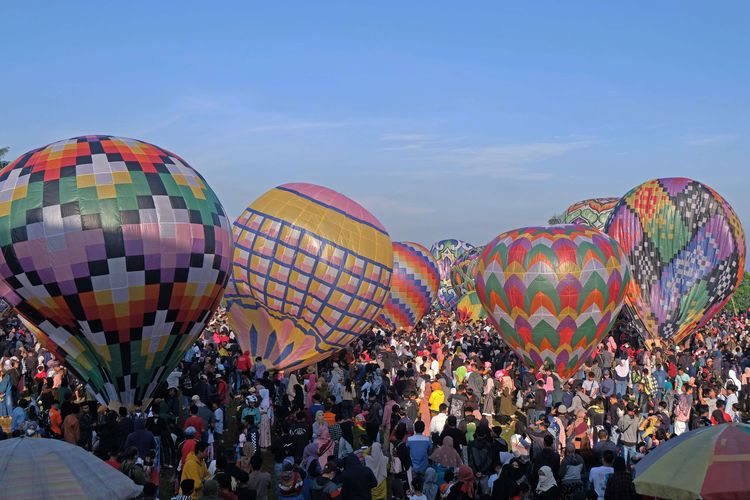 Warga menyaksikan Festival Balon Tradisional di lapangan Kembaran, Kalikajar, Wonosobo, Jawa Tengah Sabtu (6/5/2022). Setelah ditiadakan selama dua tahun akibat pandemi COVID-19 festival tersebut kembali digelar dan diikuti puluhan kelompok dengan berbagai kreasi balon warna-warni berbahan kertas.