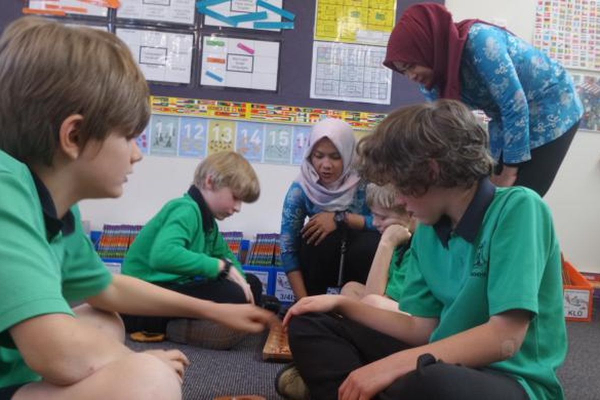 Anak-anak usia sekolah dasar di Turner School mengikuti pelajaran Bahasa Indonesia melalui permainan tradisional congklak. Dyah Candra Arbiningrum dan rekannya, guru dari Pangkalan Bun, Kalimantan Tengah, ikut mengajar sebagai guru pendamping saat mengikuti program Bridge.