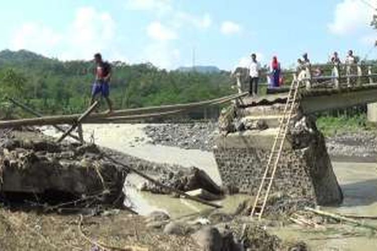 Dengan menggunakan bambu sebagai jembatan darurat, warga Dusun Slentho, Desa Kaliputih, Kecamatan Singorojo, Kabupaten Kendal, Jawa Tengah, menyeberangi Sungai Kaliputih. Jembatan itu kembali putus akibat diterjang aliran deras sungai setelah hujan deras.