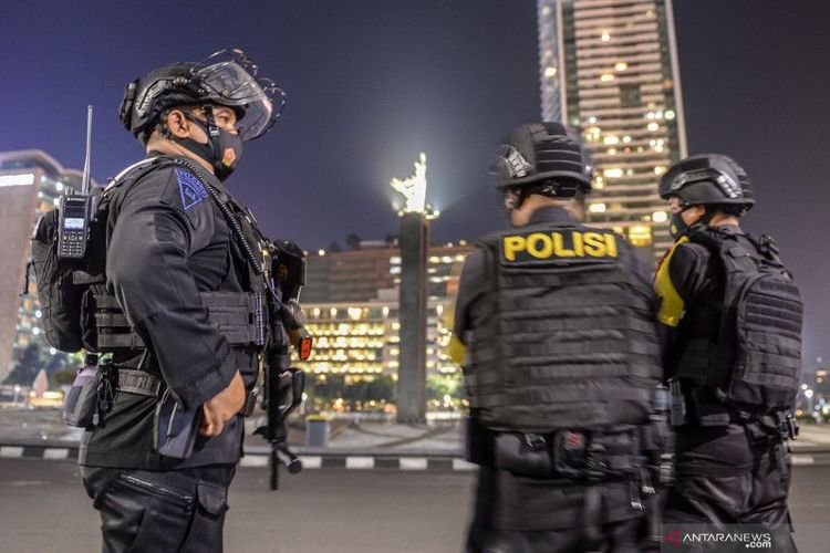 Sejumlah personel Satbrimob Polda Metro Jaya berjaga di Bundaran Hotel Indonesia, Jakarta, Jumat (31/12/2021). 