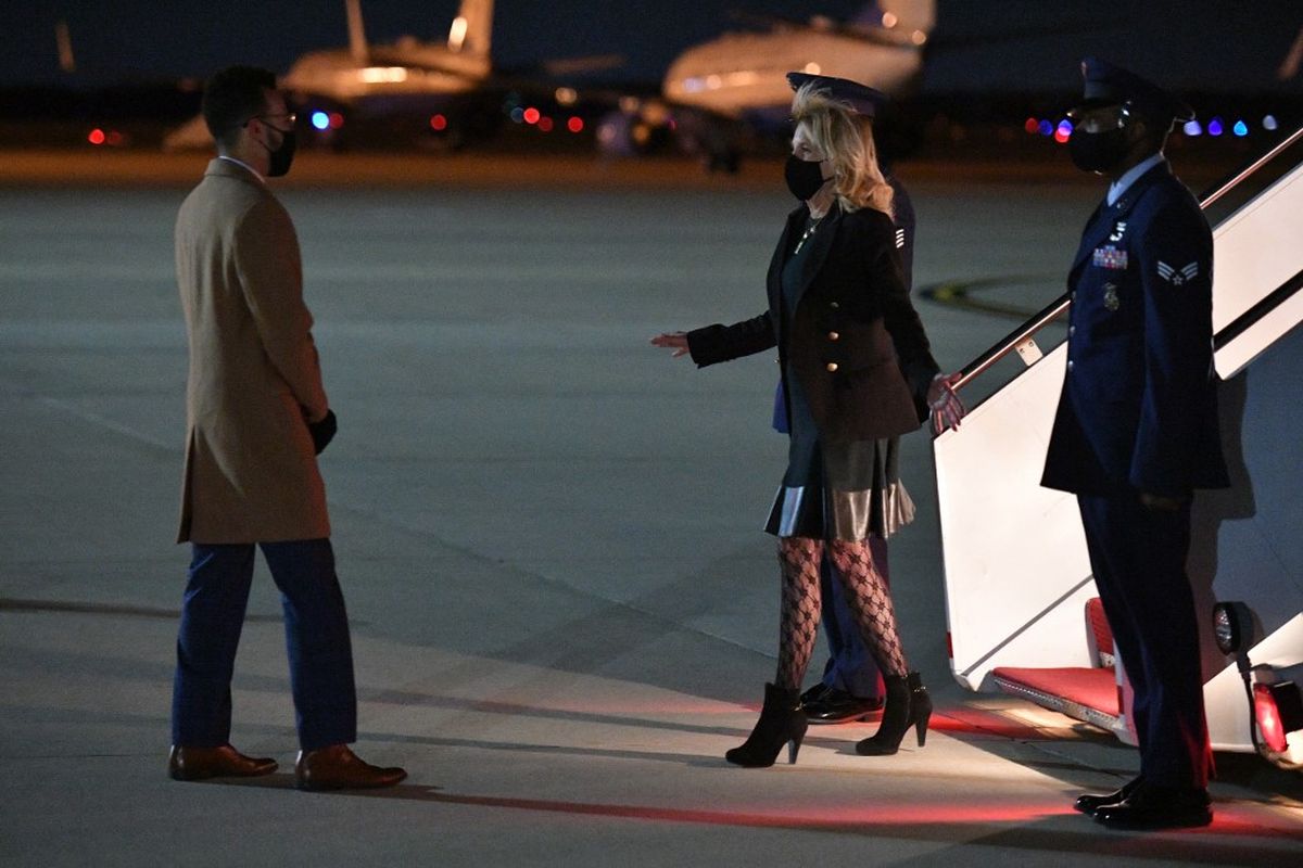 Ibu Negara Amerika Serikat Lady Jill Biden saat tiba di Andrews Air Force Base, Maryland (1/4/2021) sekembalinya dari kunjungan ke California. Penampilan Jill dengan mengenakan stoking jala mengundang perdebatan di jagat maya.  