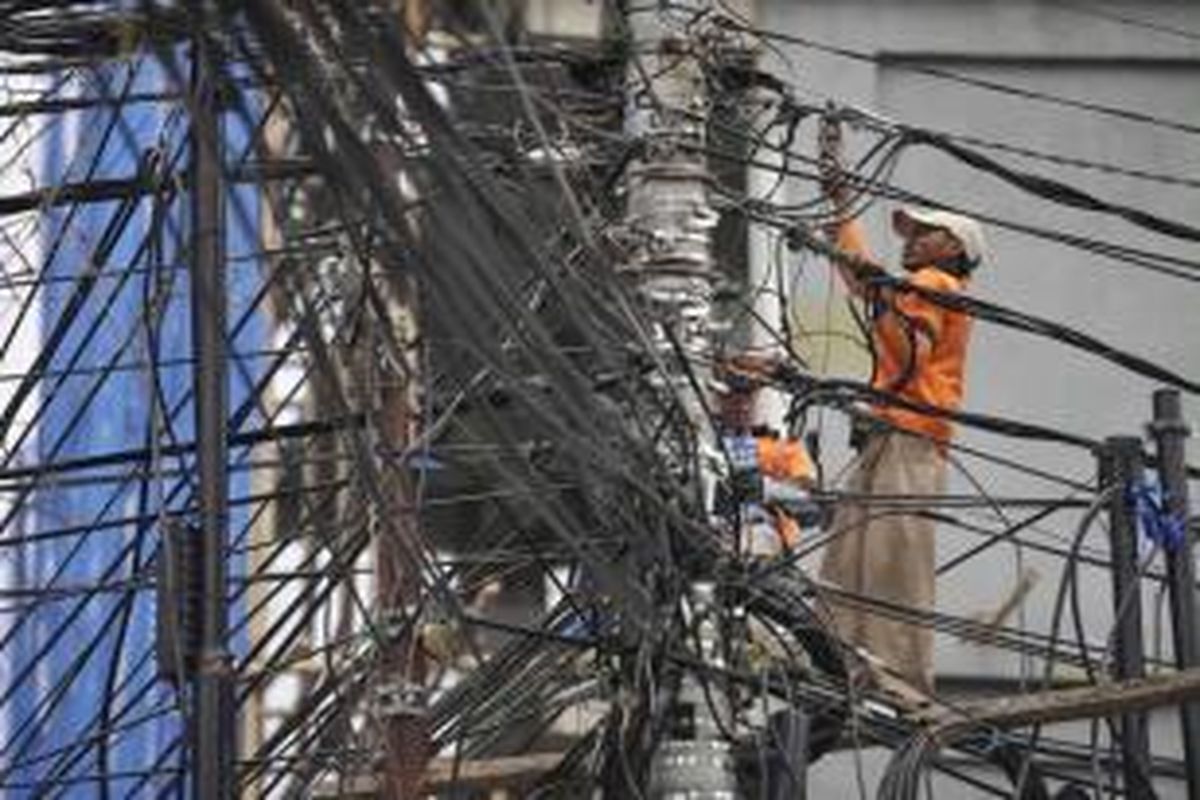 Petugas memasang sambungan baru kabel listrik PLN sebuah perkantoran di Jalan Budikemulyaan, Jakarta Pusat, Rabu (21/8/2013).