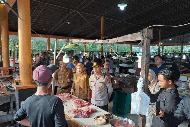 Petugas kepolisian Polres Bengkalis saat mengecek daging yang dijual di pasar pasca warga memungut daging kerbau yang dimusnahkan dengan cara dikubur, di Kabupaten Bengkalis, Riau, Selasa (30/5/2023).