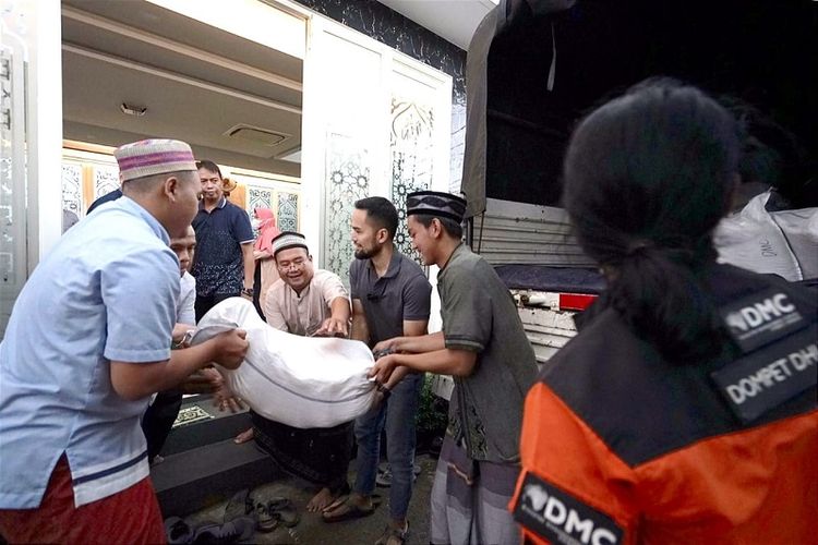 Aktivitas tebar zakat fitrah di tengah hujan deras buah sinergi Dompet Dhuafa dengan The Sungkars Family bagikan 500 pak beras 5kg untuk masyarakat pra sejahtera dan dhuafa di kawasan Karang Tengah, Lebak Bulus, Jakarta Selatan, Senin (25/4/2022).