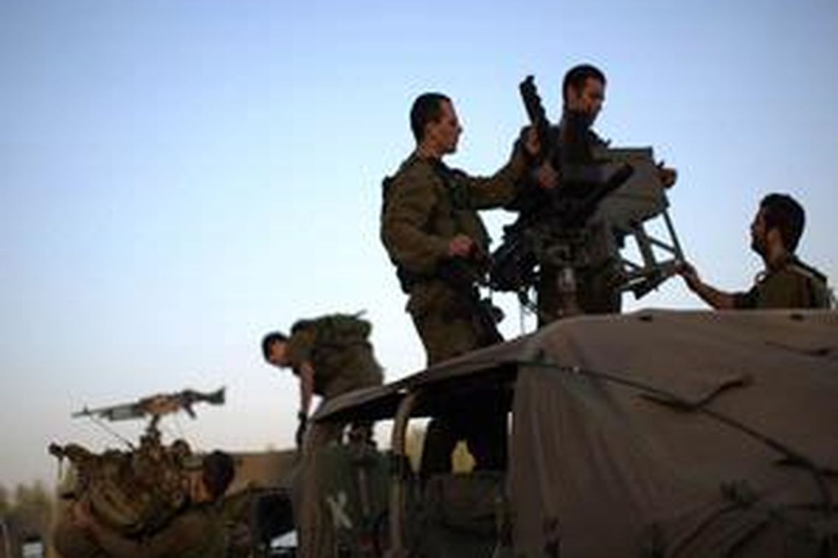 Tentara Israel menyiapkan amunisi ke dalam mobil di perbatasan Gaza, Minggu (28/12). 