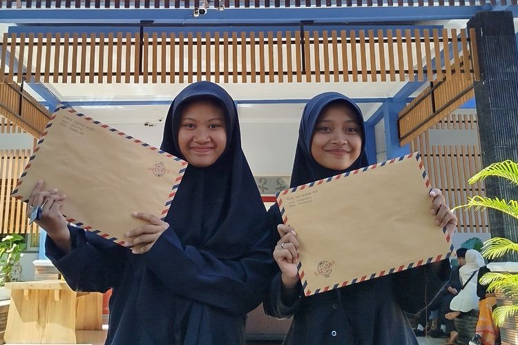 Maria Sintia dan Putri Ayu saat menunjukkan berkas pendaftaran mereka ke jenjang SMK, Kamis (5/6/2025).