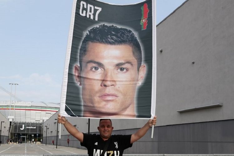 Seorang suporter membentangkan suporter Cristiano Ronaldo ketika sang megabintang tiba di markas Juventus pada 16 Juli 2018. 